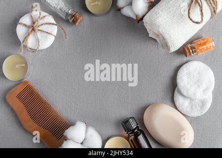 Spa-Accessoires und Kosmetik auf grauem Texturhintergrund. Handtuch, Seife, Haarbürste, ätherisches Öl. Natürliche umweltfreundliche Wellness-Produkte, keine Verschwendung. C Stockfoto