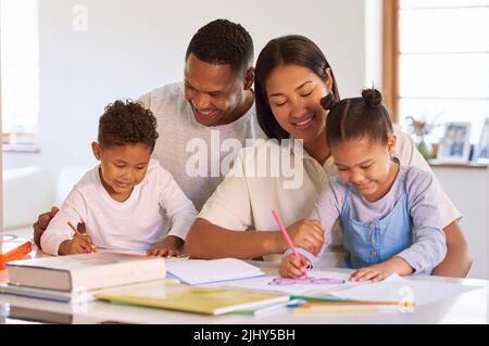 Glückliche kleine Kinder, die mit ihren Eltern lernen und Hausaufgaben machen. Gemischtes Rennen Paar Heimschooling Vorschule Sohn und Tochter zu Hause. Hispanische Mutter Stockfoto