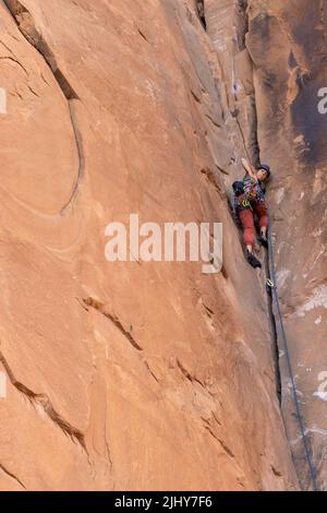 Klettererin auf Sandsteinklippen bei Moab, Utah Stockfoto