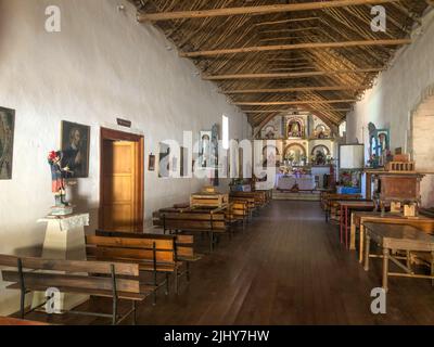 Das Kirchenschiff und die Altarpfeize im Inneren der Kirche des Heiligen Franziskus von Assisi in Socoroma, Chile. Stockfoto