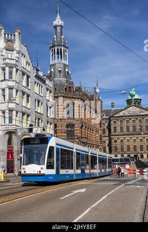 GVB-Straßenbahn auf der Raadhuisstraat mit Magna Plaza und dem Königspalast, Niederlande Stockfoto