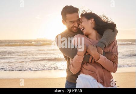 Junges, vielfältiges Biracial-Paar, das gemeinsam am Strand Spaß hat Stockfoto