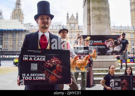 London, Großbritannien. 21.. Juli 2022. Demonstranten halten Plakate und Käfige mit Plüsch-Hühnerspielzeug. Aktivisten der Humane League UK versammelten sich vor dem Parlament, um die Regierung aufzufordern, engen, grausamen Käfigen ein Ende zu setzen, in denen eierlegende Hühner häufig gehalten werden. Der Protest markiert 200 Jahre seit dem ersten Tierschutzgesetz Großbritanniens, bei dem mehrere Aktivisten historische Kleidung trugen. Kredit: Vuk Valcic/Alamy Live Nachrichten Stockfoto