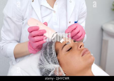 Schöne Frau mit Ultraschall, Kavitation Facial Peeling. Kosmetik und Gesichtspflege Stockfoto