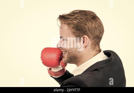 Glücklicher Geschäftsmann trägt Boxhandschuh und Business-Anzug isoliert auf weißen, kämpfenden Mann Stockfoto