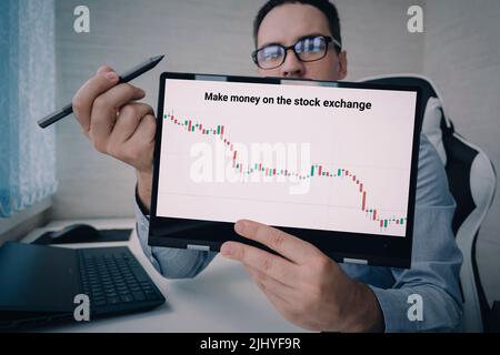 Junger Unternehmensberater mit Laptop und weißem Bildschirm. Fernschulungskonzept. Business Coach. Börsenberater Stockfoto