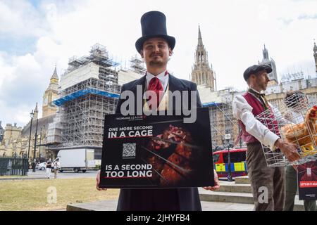 London, Großbritannien. 21.. Juli 2022. Aktivisten der Humane League UK versammelten sich vor dem Parlament, um die Regierung aufzufordern, engen, grausamen Käfigen ein Ende zu setzen, in denen eierlegende Hühner häufig gehalten werden. Der Protest markiert 200 Jahre seit dem ersten Tierschutzgesetz Großbritanniens, bei dem mehrere Aktivisten historische Kleidung trugen. Kredit: Vuk Valcic/Alamy Live Nachrichten Stockfoto