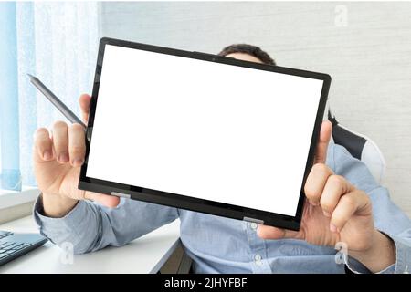 Der Mann zeigt einen Tablet-Bildschirm. Ein Tablet mit einem leeren weißen Bildschirm in Männerhänden und einem Tablet. Der Coach demonstriert im Büro einen Computer. Online t Stockfoto