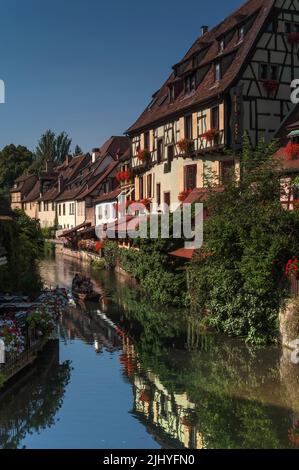 In Colmar, Elsass, Grand Est, Frankreich, reisen Touristen in Flachbodenbooten auf geführten Touren durch Little Venice (La Petite Venise), mit seinem farbenfrohen Flussufer aus alten Fachwerkhäusern in der Lauch. Stockfoto