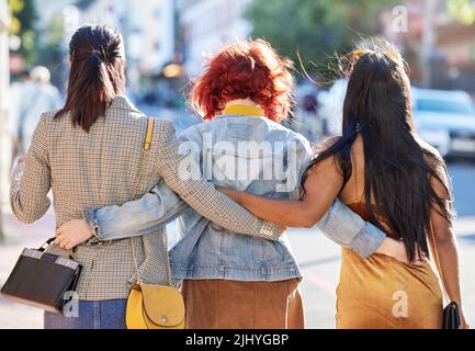 Raus in die Stadt. Rückansicht von drei nicht erkennbaren jungen Freundinnen in der Stadt. Stockfoto