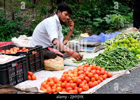 Bagdogra, Westbengalen, Indien. 24. Juni 2022. Ein Dorfmann, der auf der Straßenseite eines belebten Gebiets auf dem lokalen Markt sitzt, um sein Gemüse zu verkaufen. Stockfoto