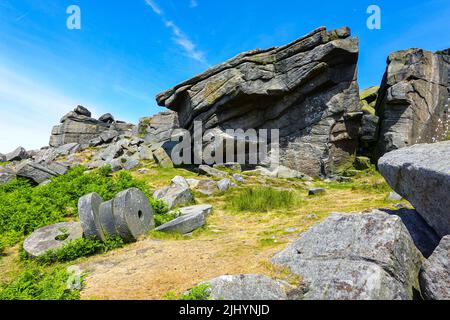 Verlassene Mühlsteine unter Stanage Edge, Gritstone Cliff, Peak District National Park, Derbyshire, Großbritannien Stockfoto