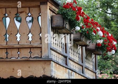 Holzbalkon-Konstruktion mit Geranien Stockfoto