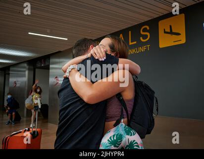 Eine Frau umarmte den Mann nach der Ankunft von der Reise Stockfoto