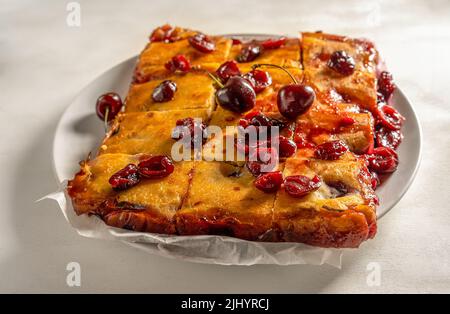 Frisch gebackene süße Kirschkuchen oder roter Brownie-Kuchen aus nächster Nähe auf dem Teller Stockfoto