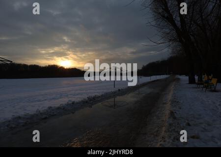 Sonnenuntergang am Flussufer in der Stadt Stockfoto