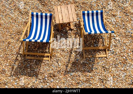 Zwei einlähige Liegestühle an einem Kieselstrand mit viel Platz für Kopien Stockfoto