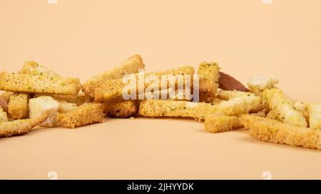 Brotcroutons aus der Nähe, Biersnacks auf beigem Hintergrund. Stockfoto