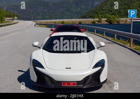 Super cars, white McLaren 650s and red Ferrari F12 in the back, parked by the road. Miland, Norway. 04.06.2016 Stockfoto