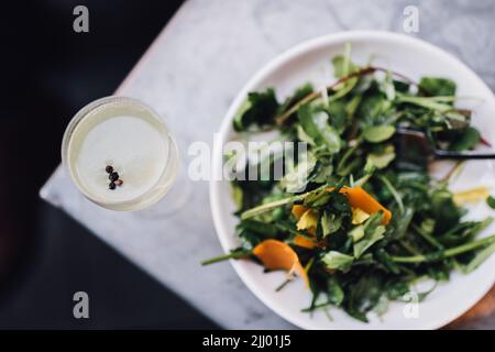 Wildwasser-Salat mit Erbsen und Orangenmimolette Stockfoto