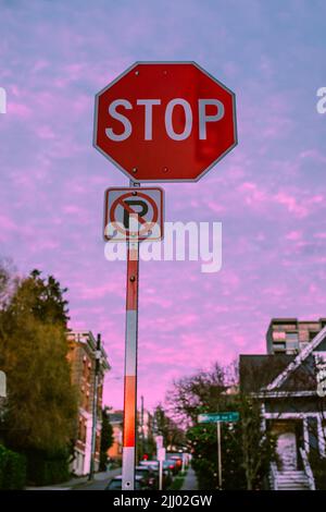 Stoppschild, kein Parkschild bei Sonnenuntergang mit rosa Himmel auf der Bellevue Street im Capitol Hill Viertel von Seattle Stockfoto