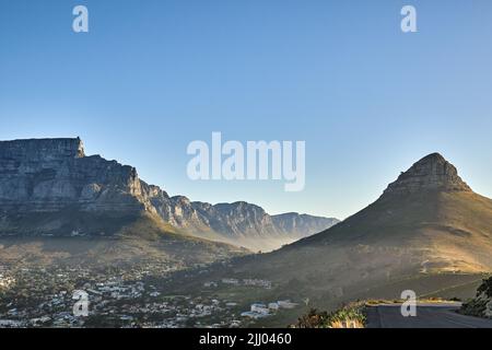 Berghintergrund, Landschaft von Tafelberg und Vorort mit privaten Häusern vor blauem Himmel Hintergrund mit Copyspace. Wunderschöne Aussicht auf Stockfoto