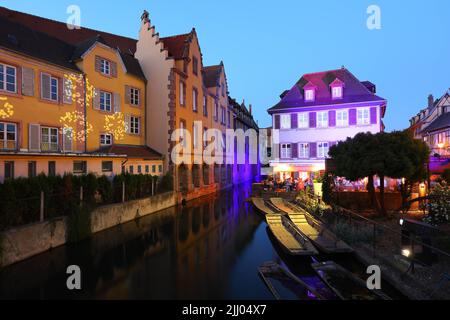 Colmar, Elsass, Frankreich April 2022 : traditionelle Fachwerkhäuser und Restaurants auf der Straße in Colmar in der Dämmerung, Elsass Rigion, Frankreich Stockfoto