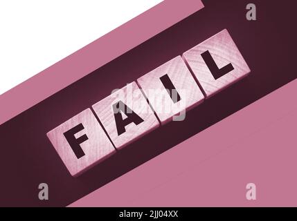 FAIL Word-Text in Holzwürfelblöcken auf schwarzem Hintergrund geschrieben. Krisenkonzept Stockfoto