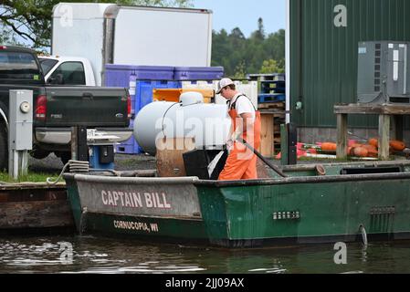 Ein Fischer arbeitet am Dock von Halvarsan Fisheries in Cornucopia, WI am Lake Superior. Stockfoto