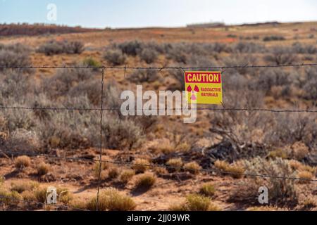 White Mesa, Utah - Ein Warnschild für „radioaktive Materialien“ auf einem dünnen Zaun um Teiche bei der White Mesa Mill von Energy Fuels Resources. Die Teiche wuerden Stockfoto