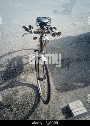 Antikes Fahrrad, das am Straßenrand in gutem Zustand geparkt ist Stockfoto