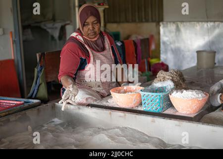 Terengganu, Malaysia: 16. Jan 2022 - Eine Frau, die den berühmten Keropok-Lekor oder die Fischwurst macht Stockfoto