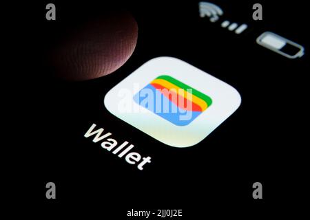 Neue Google Wallet App auf dem Bildschirm des Smartphones und Fingertipp darüber gesehen. Google Pay umbenannt in Google Wallet. Stafford, Großbritannien, Juli Stockfoto