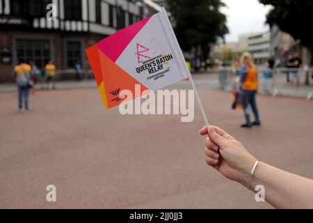 Eine Flagge des Baton-Staffelauftritts der Commonwealth Games, wenn der Baton der Königin durch das Zentrum von Coventry fährt. Stockfoto