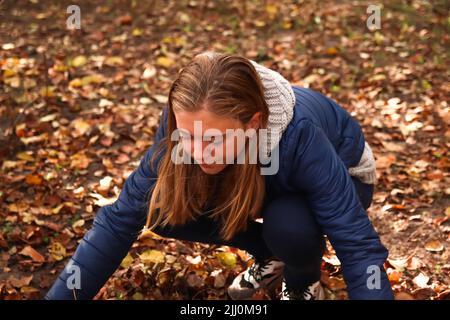 Unschärfen Sie Herbstmenschen. Teen Mädchen sammeln trockene Blätter. Viele fliegende orange, gelbe, grüne trockene Blätter. Genießen Sie den Herbst. Alles gute im Herbst. Lustige Jahreszeit. Laub. Okt Stockfoto