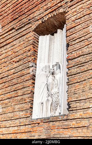 Bas Relief eines Adlers und Ziegelmauer Stockfoto