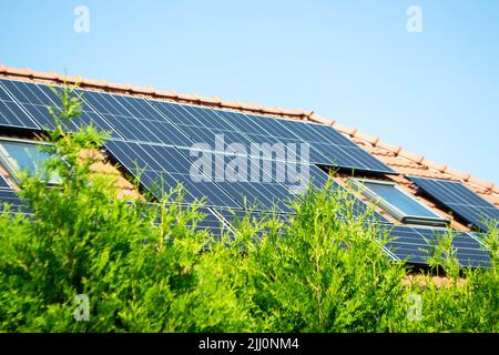 Hausdach mit Photovoltaikmodulen. Historisches Bauernhaus mit modernen Sonnenkollektoren auf Dach und Wand Hochwertiges Foto Stockfoto