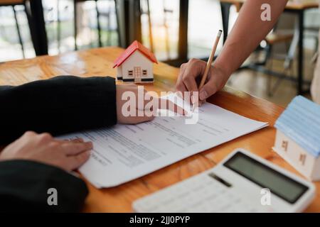 Immobilienkonzept. Geschäftsmann, der auf den Vertragsvertrag verweist. Stockfoto