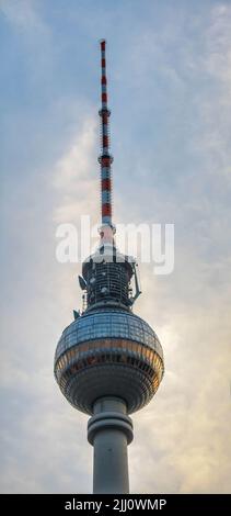 Nahaufnahme der Spitze des Fernsehturms oder des Berliner Fernsehturms im Sommer mit Wolken im Hintergrund des blauen Himmels. Stockfoto