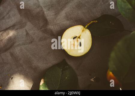 Geschnittene reife Birne auf einem Holztisch, Cottage-Ästhetik Stockfoto