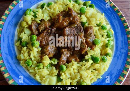 Rindfleisch Korma serviert auf einem bunten Teller Stockfoto