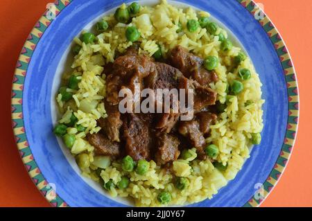 Rindfleisch Korma serviert auf einem bunten Teller Stockfoto