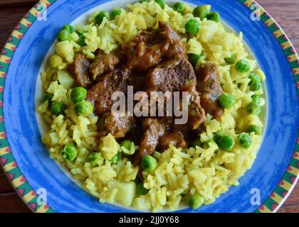 Rindfleisch Korma serviert auf einem bunten Teller Stockfoto