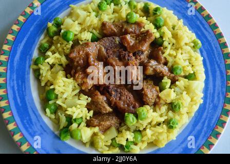 Rindfleisch Korma serviert auf einem bunten Teller Stockfoto