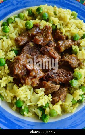 Rindfleisch Korma serviert auf einem bunten Teller Stockfoto