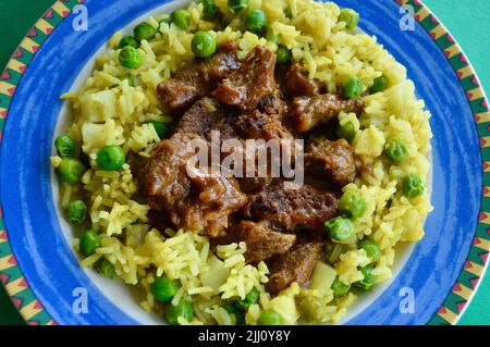 Rindfleisch Korma serviert auf einem bunten Teller Stockfoto