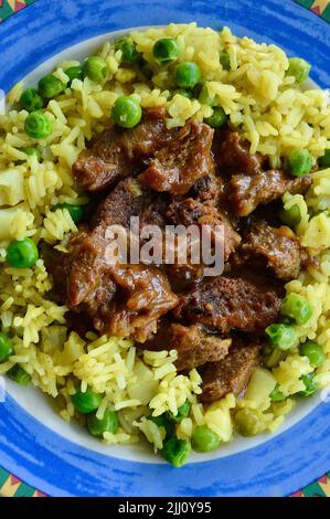 Rindfleisch Korma serviert auf einem bunten Teller Stockfoto