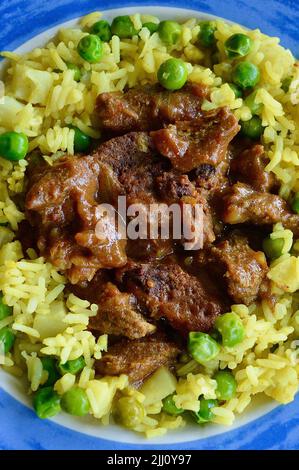 Rindfleisch Korma serviert auf einem bunten Teller Stockfoto