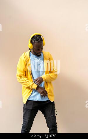 afrikanischer Mann, der mit seinen Kopfhörern zum Rhythmus der Musik tanzt Stockfoto