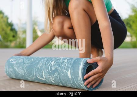 Nahaufnahme eines Mädchens mit einer Yogamatte. Stockfoto